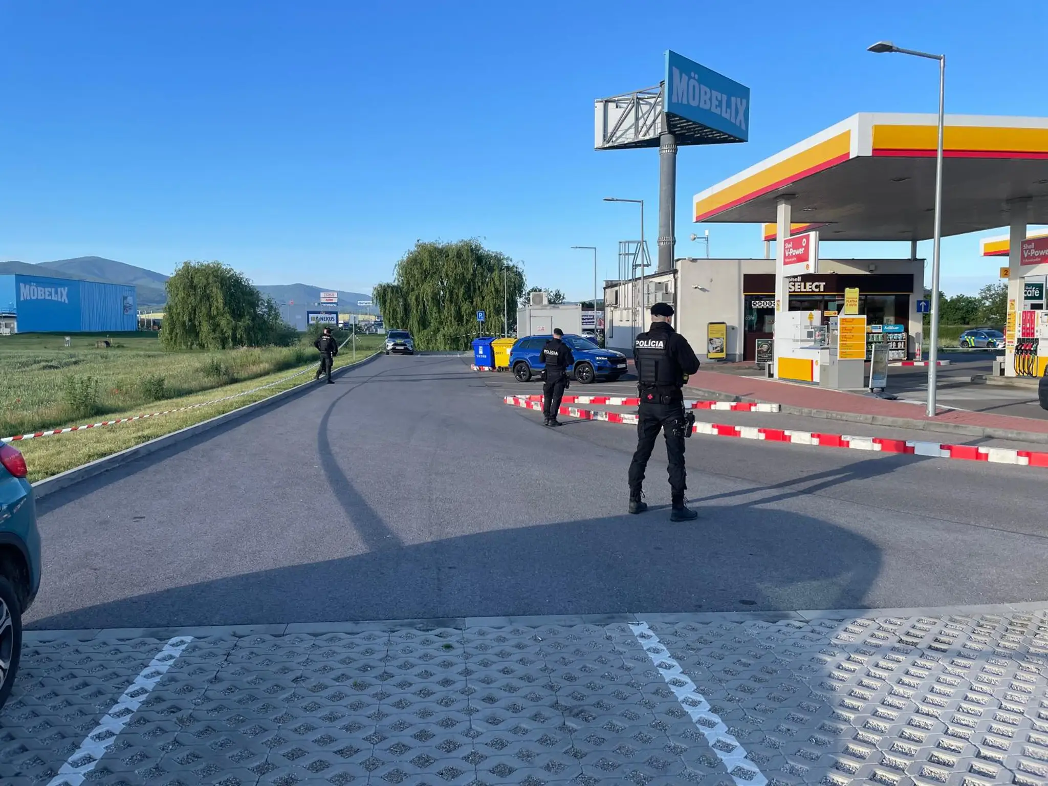 Policajti hliadkujú pred čerpačkou.