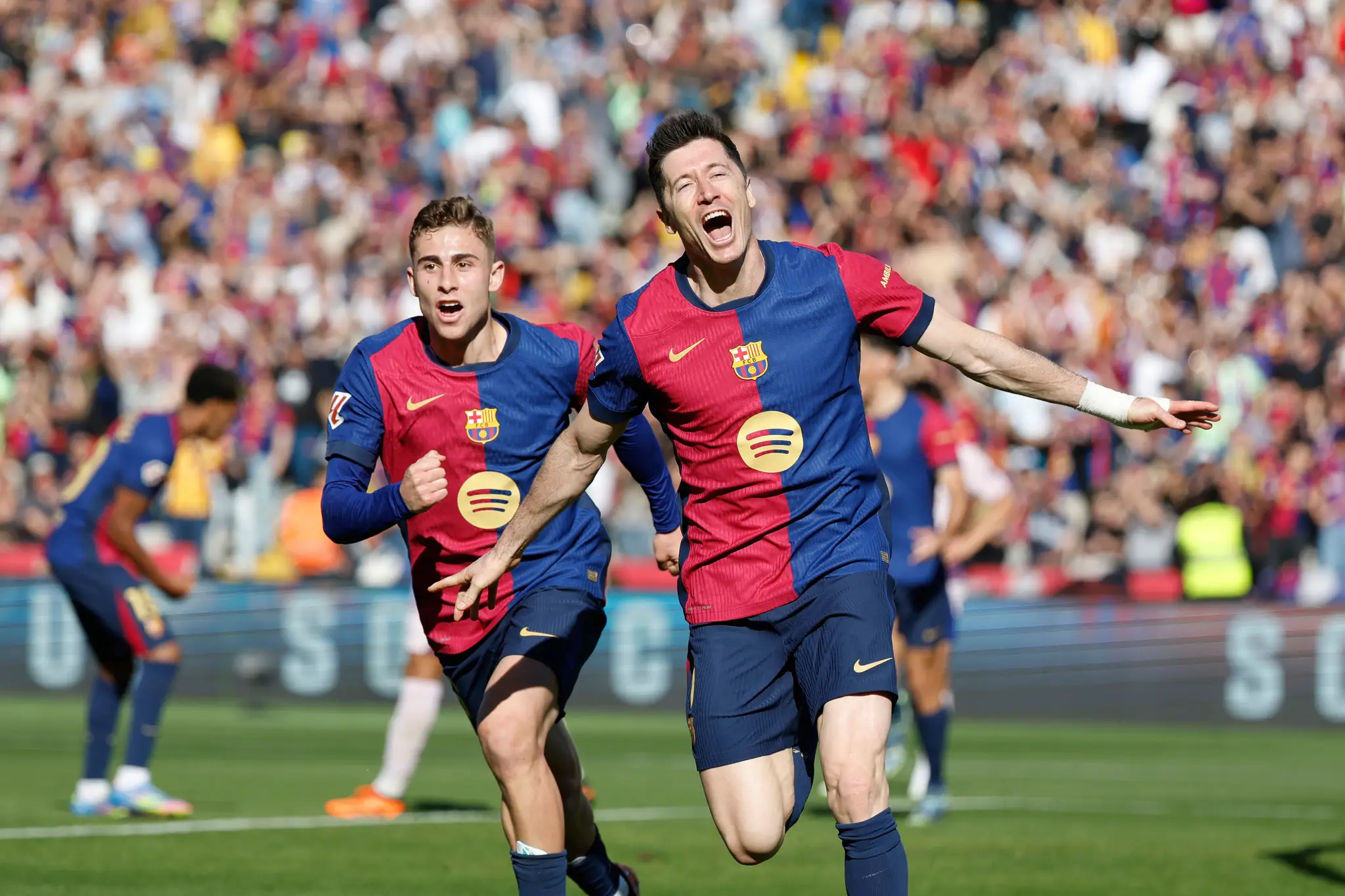 Futbalista Barcelony Robert Lewandowski (vpravo) sa teší z gólu.