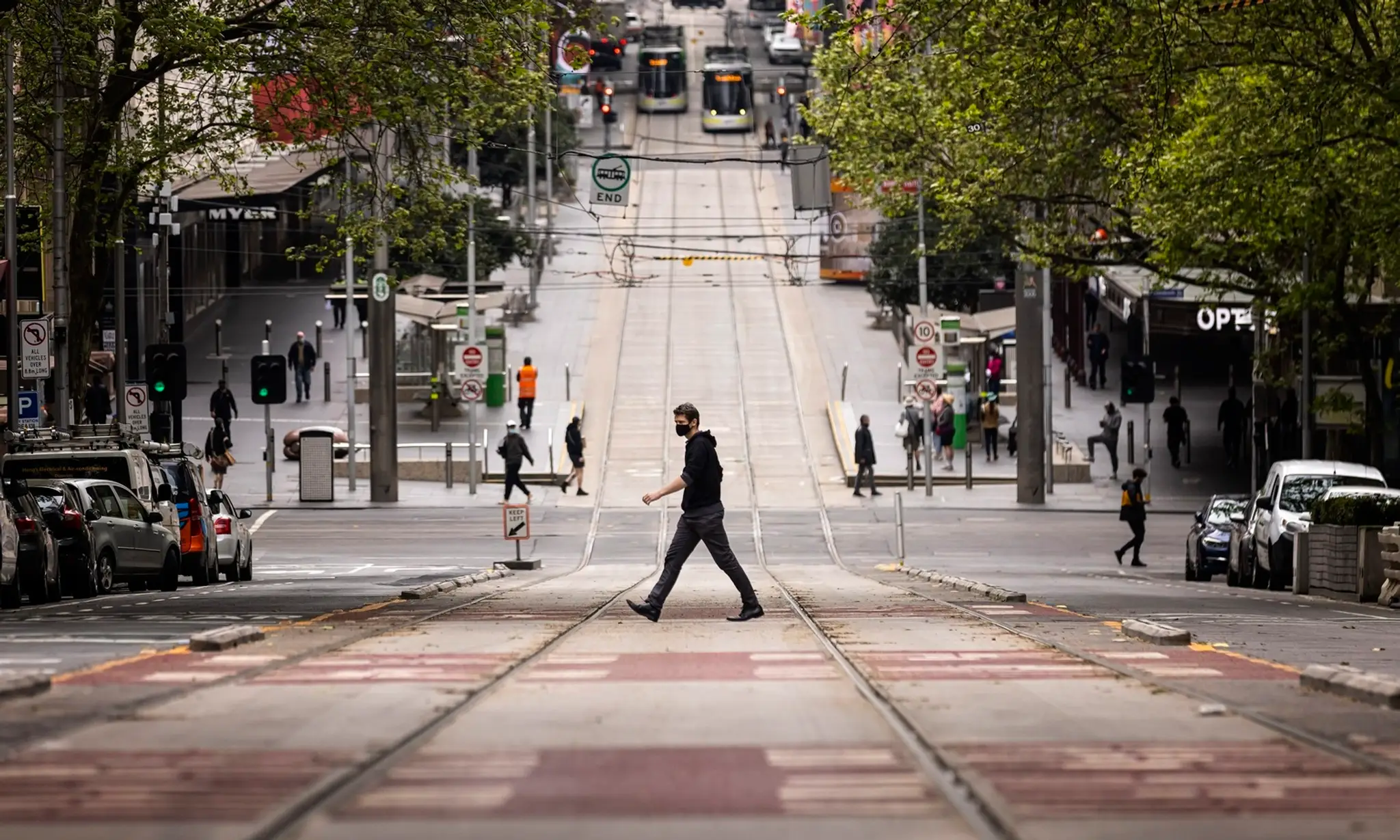 Na archívnej snímke z 30. septembra 2021 ľudia kráčajú cez cestu v Melbourne.