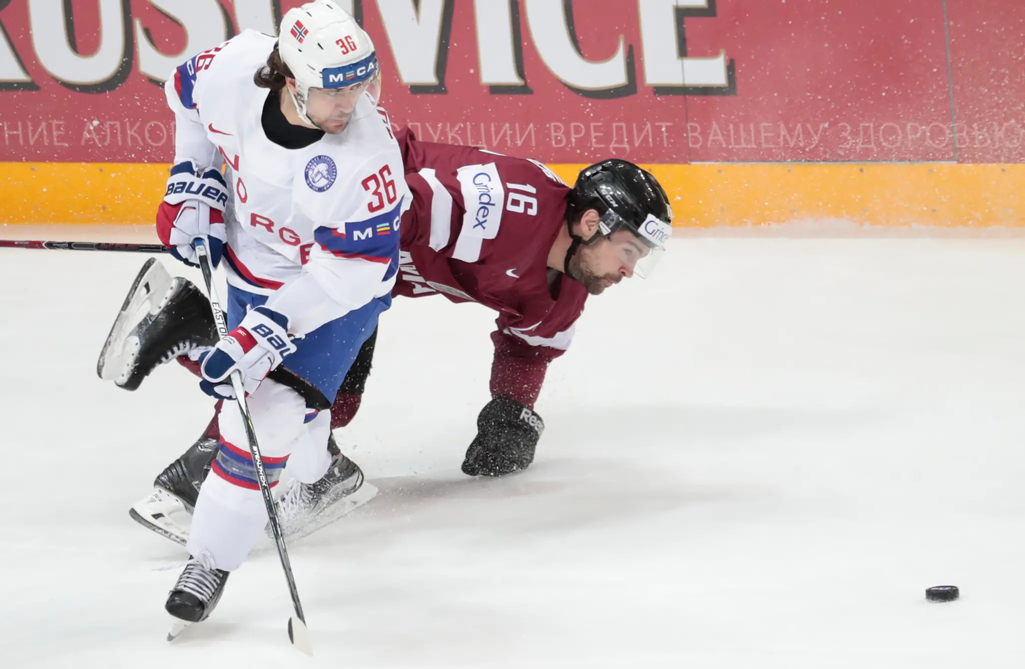 Nórsky hráč Mats Zuccarello (vľavo) v súboji s Lotyšom Kasparsom Daugavinsom v zápase na MS v Rusku.