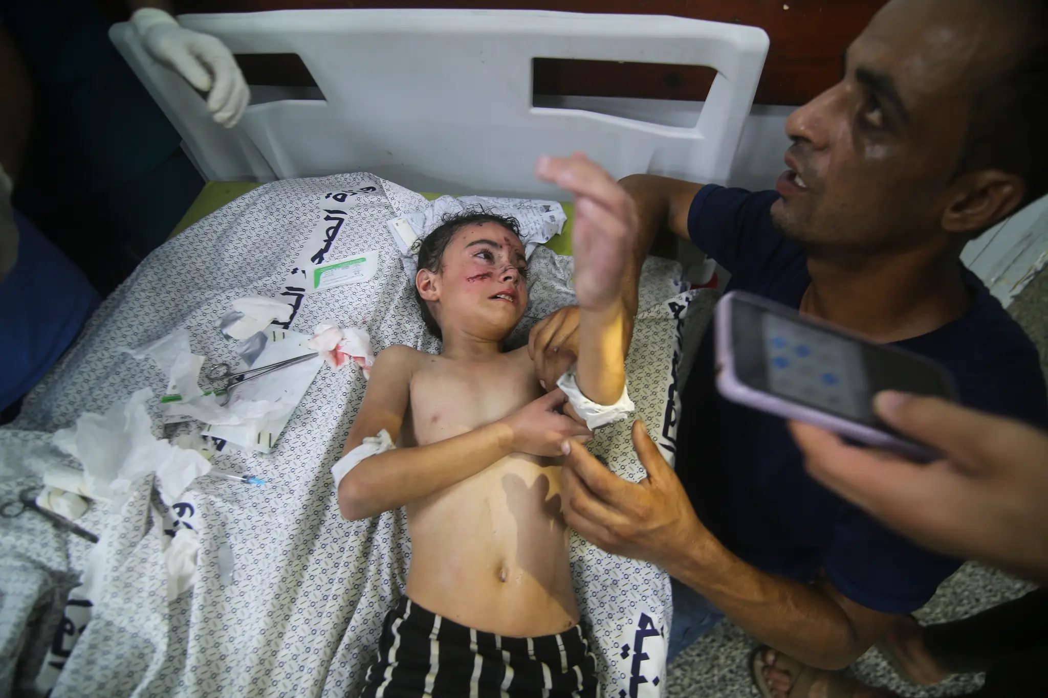 Palestínčania sedia pred ich zničeným domom po izraelskom leteckom útoku v utečeneckom tábore Rafah na juhu pásma Gazy