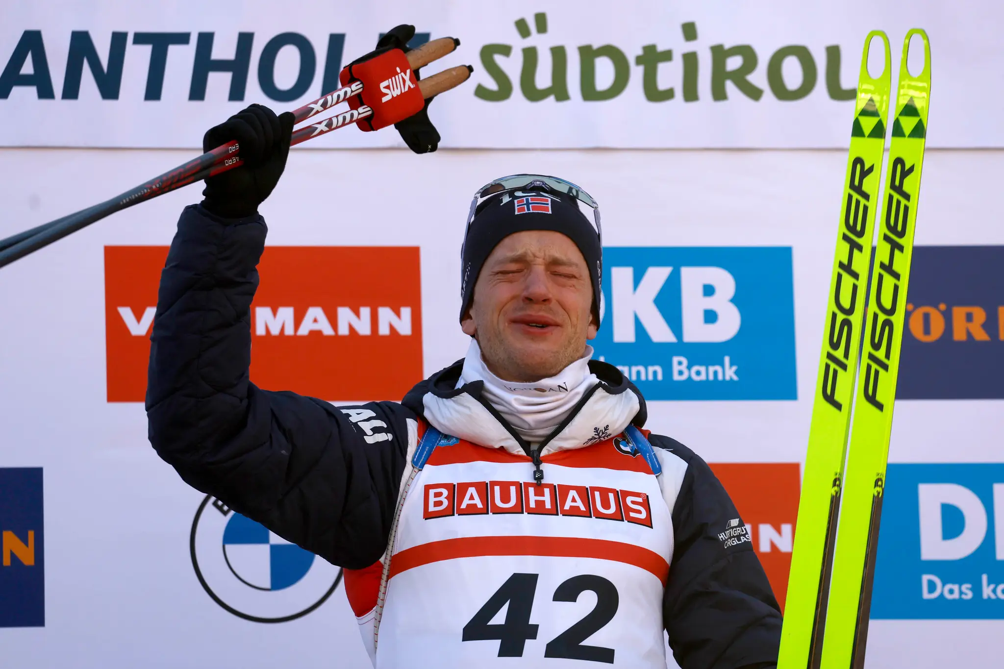 Nórsky biatlonista Tarjei Bö oslavuje na pódiu po jeho víťazstve