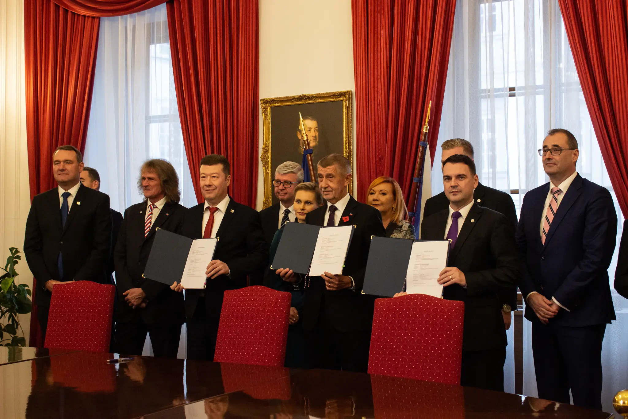Na snímke v popredí zľava predseda hnutia SPD Tomio Okamura, predseda hnutia ANO Andrej Babiš a predseda strany Motoristi sebe Petr Macinka pózujú po podpise koaličnej zmluvy v Prahe.