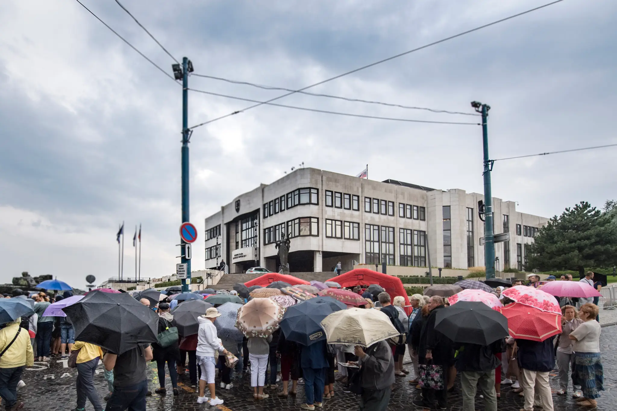 Ľudia čakajú v daždi na vstup do parlamentu počas Dňa otvorených dverí v Národnej rade SR.