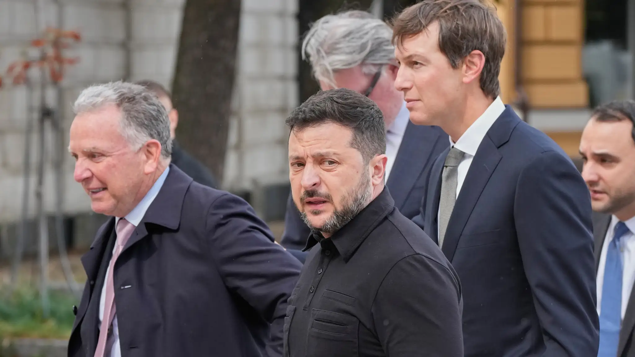 Vyslanci amerického prezidenta Jared Kushner (druhý vpravo) a Steve Witkoff (vľavo) a ukrajinský prezident Volodymyr Zelenskyj (uprosted) kráčajú pred spoločnými rozhovormi v Kyjeve.