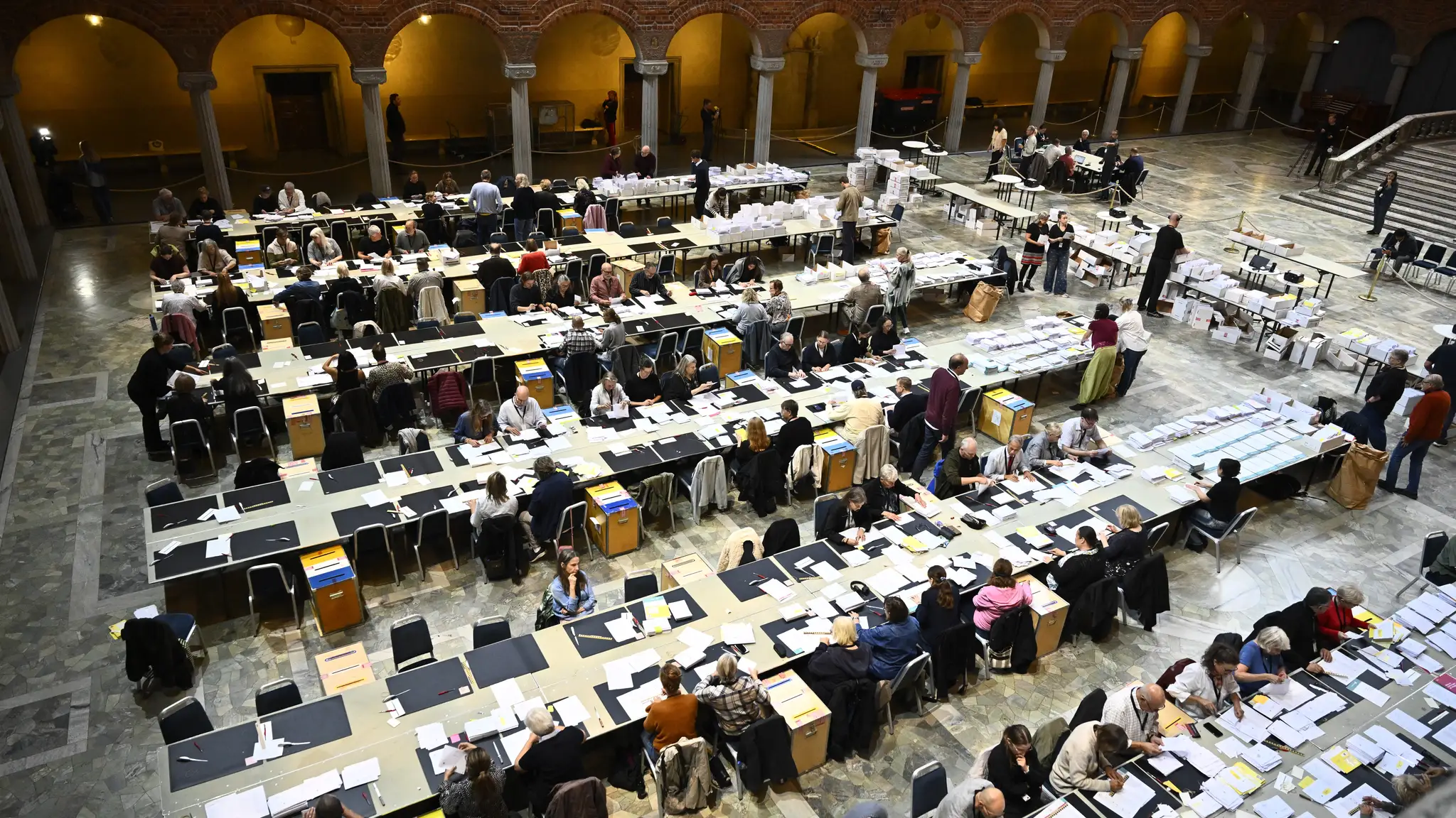 Pracovníci volebnej komisie sčítavajú predčasné hlasy a hlasy od voličov v zahraničí na radnici v Štokholme.