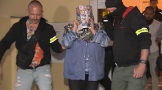 Manželku atentátnika z Handlovej odviedla polícia. Tvár si zakrývala letákom