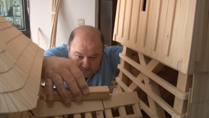 Muž pracuje na makete cerkvi