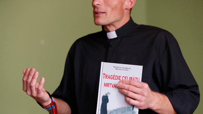 Michal Lajcha drží v ruke výtlačok knihy Tragédia celibátu: Mŕtva manželka, ktorej je spoluautorom.