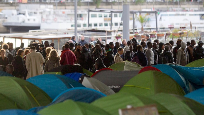 Utečenci v Paríži pred odchodom zo stanového tábora.
