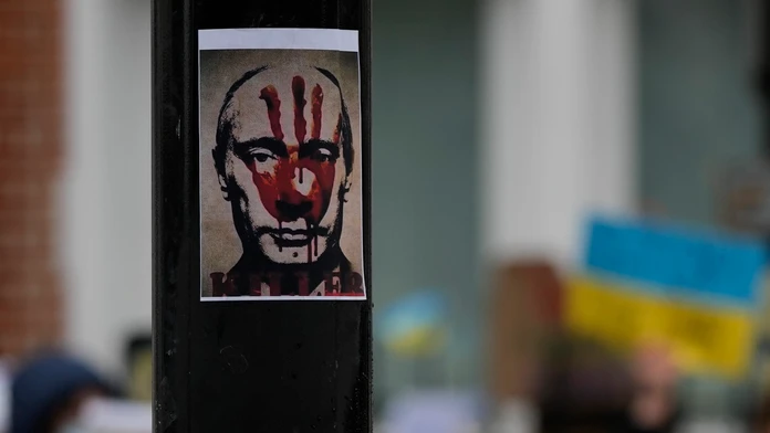 Plagát s krvavým odtlačkom dlane na tvári ruského prezidenta Vladimira Putina visí na stĺpe počas protestu proti vojne na Ukrajine
