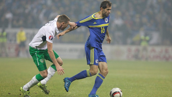 Írsky hráč James McCarthy v barážovom stretnutí drží za tričko Senada Luliča (Bosna a Hercegovina).