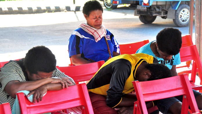 Príbuzní cestujúcich sedia na letisku a čakajú na správy o indonézskom lietadle.
