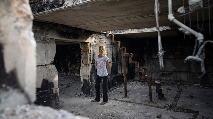 Hanna Dynaeva stojí vo svojom dome, ktorý bol zničený ruským bombardovaním v dedine Novoselivka.