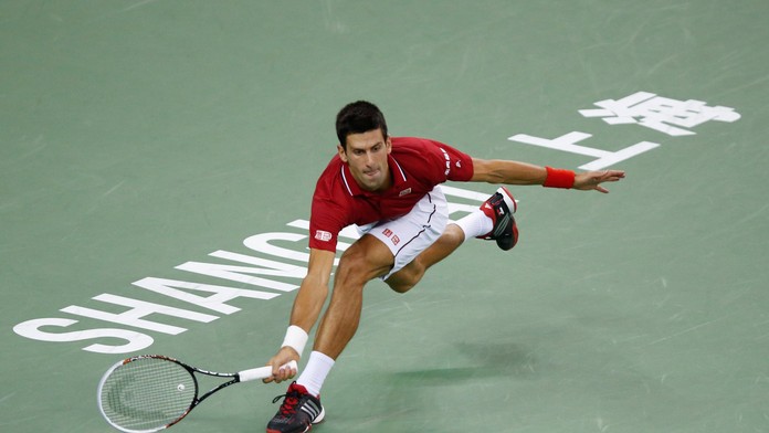 Novak Djokovič odvracia loptičku v semifinálovom zápase v Šanghaji proti Rogerovi Federerovi.