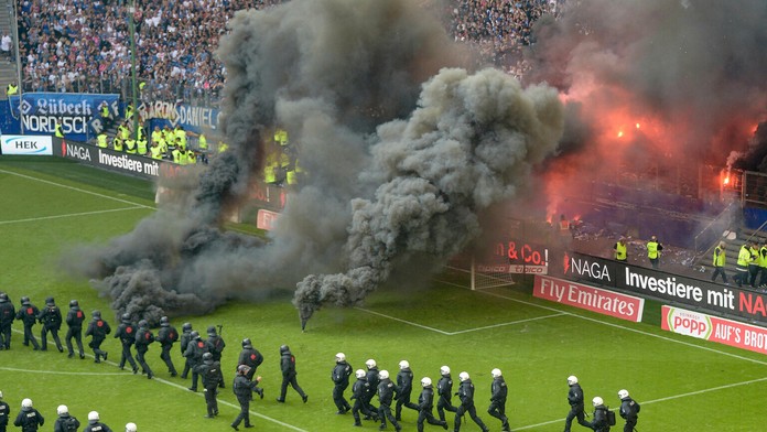 Poriadková polícia a príslušníci bezpečnostej služby sú na ihrisku po tom, čo diváci hodili na hraciu plochu svetlice.