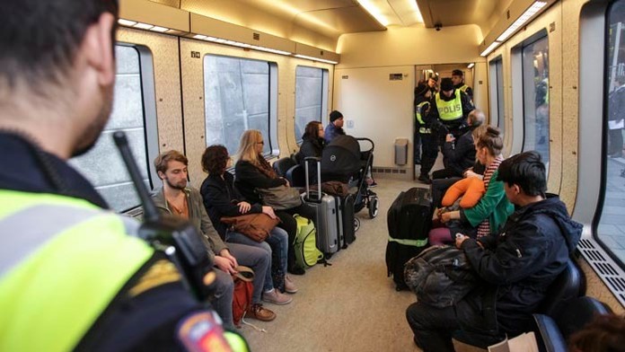 Švédski policajti kontrolujú identitu pasažierov vo vlaku z Kodane na colnici na konci mosta medzi Švédskom a Dánskom.