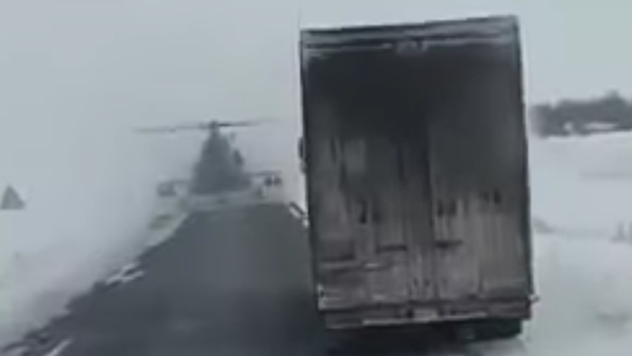 Z hmly sa vynorila bojová helikoptéra.