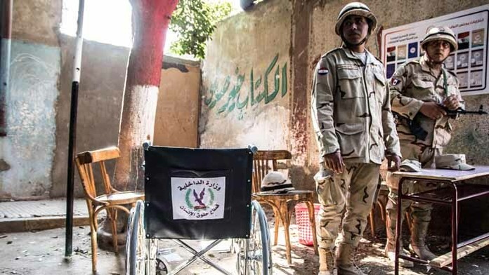 Egyptskí vojaci strážia pred volebnou miestnosťou v druhej fáze parlamentných volieb v Egypte v Káhire.