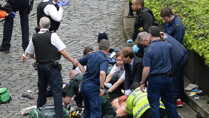 Konzervatívny poslanec Tobias Ellwood (uprostred) pomáha záchranárom.