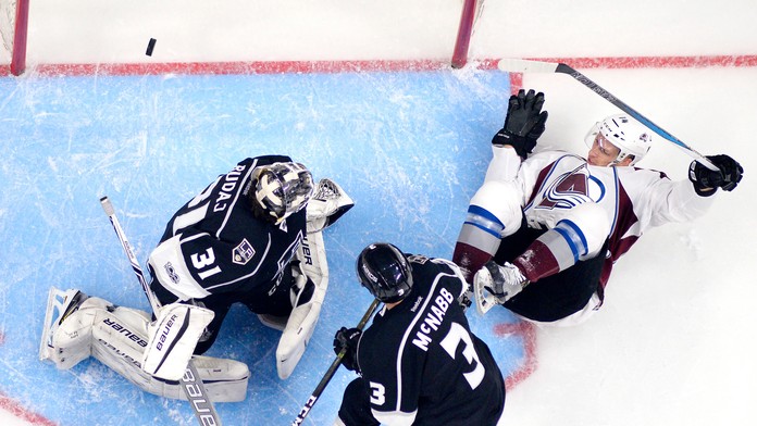 Hokejista Colorada Avalanche  Blake Comeau, brankár Los Angeles Kings  Peter Budaj  a jeho spoluhráč Brayden McNabb.