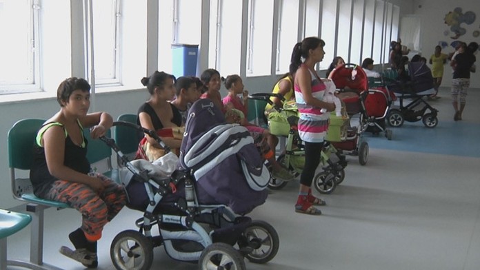 Rodičia s deťmi čakajúci na zaočkovanie proti osýpkam.