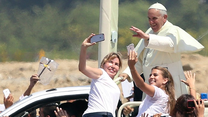 Dve ženy sa vyšplhali na zábrany, aby sa odfotili s pápežom Františkom počas príchodu do parku Samanes v ekvádorskom meste.