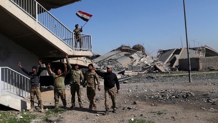 Irackí vojaci sa tešia pri moste, ktorý získali pod kontrolu od militantov IS.