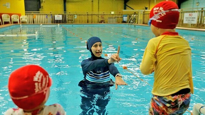 Moslimka učí deti plávať.