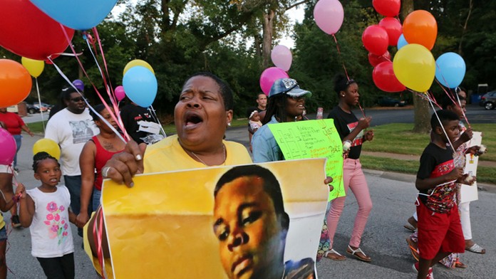 Demonštrantka drží fotografiu Michaela Browna.