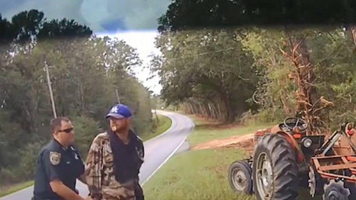 Policajt nasadzuje putá zlodejovi traktora.