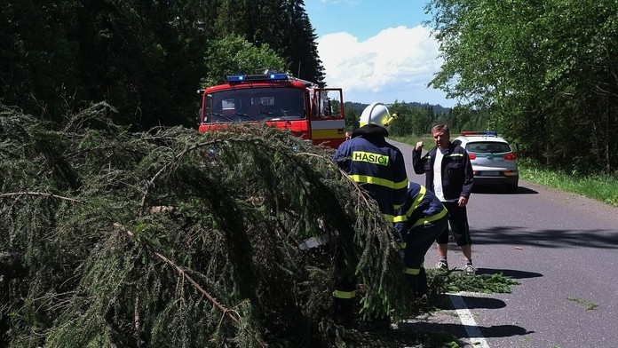 Na snímke hasiči a dobrovoľní hasiči zo Ždiaru odpratávajú popadané stromy z cesty