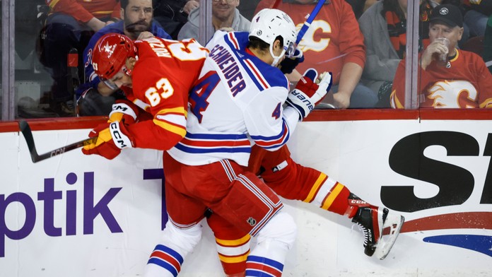Na snímke zľava slovenský útočník Calgary Adam Ružička a obranca Rangers Braden Schneider.
