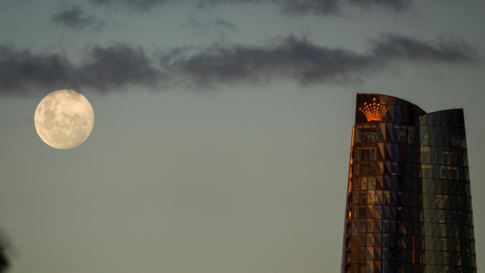 Mesiac v splne vychádza nad štvrťou Barangaroo v centre Sydney.