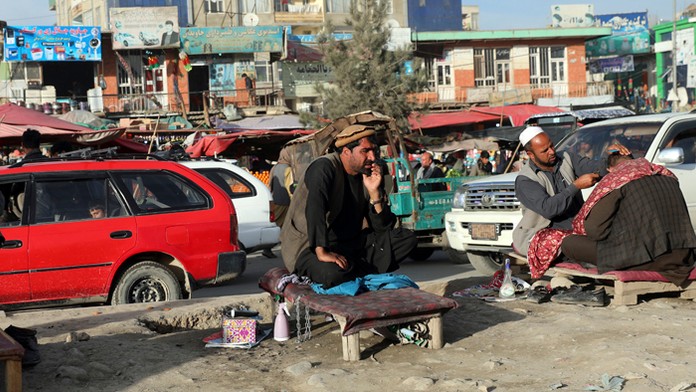 Afganský pouličný holič strihá vlasy zákazníkovi na okraji Kábulu.