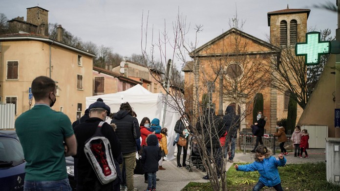 Ľudia stoja v rade so svojimi deťmi na testovanie na ochorenie COVID-19 pri Lyone.