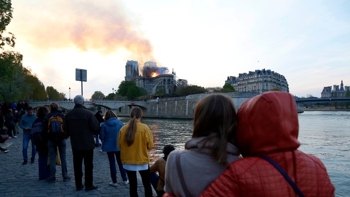 Ľudia sledujú hasenie katedrály Notre Dame.