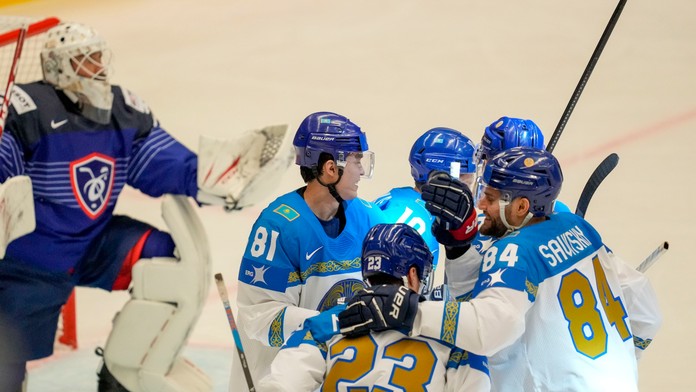  Kazašský hokejista Maxim Mukhametov sa raduje z gólu so spoluhráčmi.