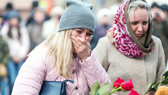 Ľudia prišli vzdať úctu obetiam požiaru. 