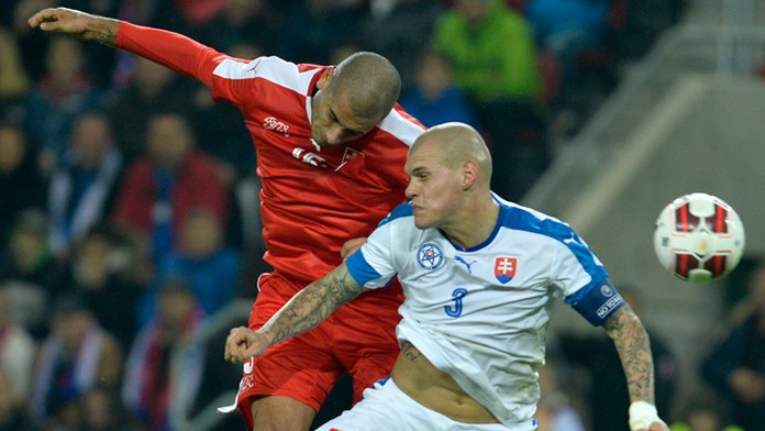 Martin Šrtel bojuje o loptu s Erenom Derdiyokom (Švajčiarsko) v prípravnom zápase na EURO 2016 v Trnave.
