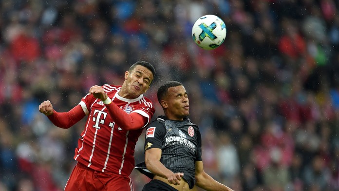 Thiago z Bayernu  (vľavo) a Robin Quaison z Mainzu bojujú o loptu.