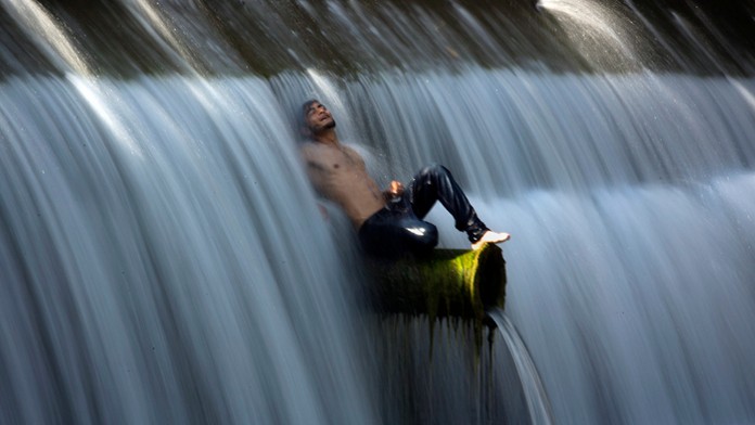 Muž sa ochladzuje v prúde vody.