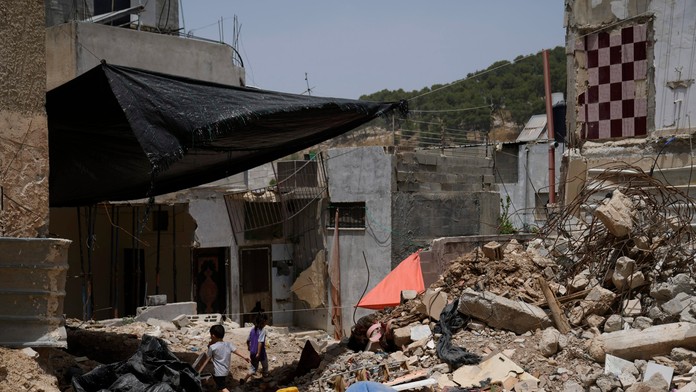 Palestínske deti sa hrajú pri troskách budov, ktoré boli zničené počas operácií izraelskej armády.