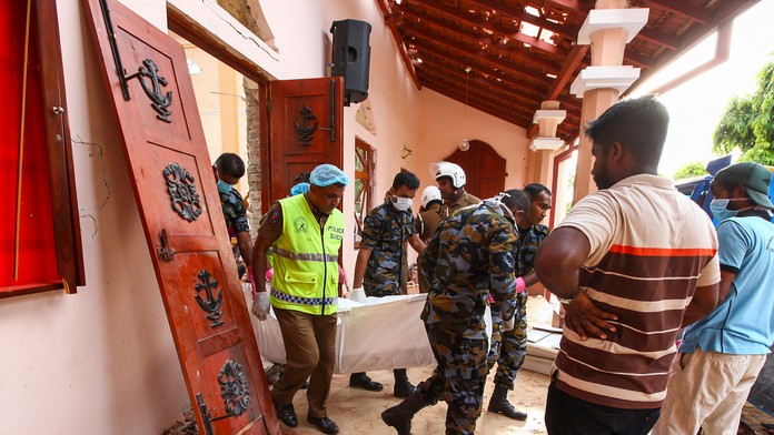 Úradníci vynášajú obeť útoku na kostol v Negombe na Srí Lanke.