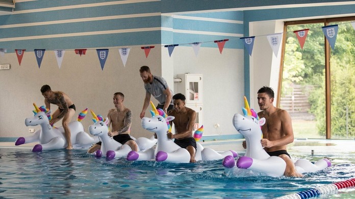 Anglickí hráči šantia v bazéne.