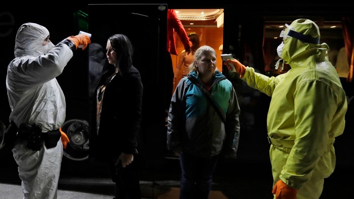 Na snímke zdravotníci v ochrannom odeve merajú teplotu cestujúcim na hraničnom priechode Českej republiky s Nemeckom v Rozvadove