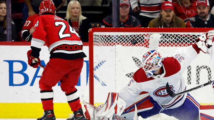 Hokejista Caroliny Hurricanes Seth Jarvis prekonáva brankára Montrealu Canadiens Sama Montembeaulta.