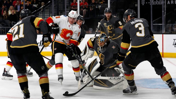 Gólman Las Vegas Marc-Andre Fleury chytá strelu Matthewa Tkachuka z Calgary (v bielom) v dueli NHL.