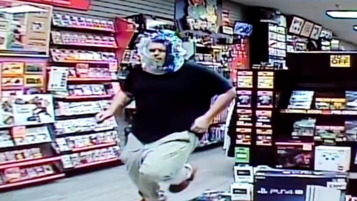 Zlodej uteká z predajne s igelitovým vreckom na hlave.