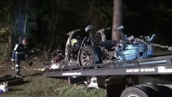 Vrak zhorenej Tesly na korbe odťahového vozidla.